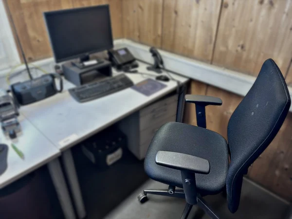 Schreibtisch mit Rollcontainer und Bürodrehstuhl ohne Inhalt