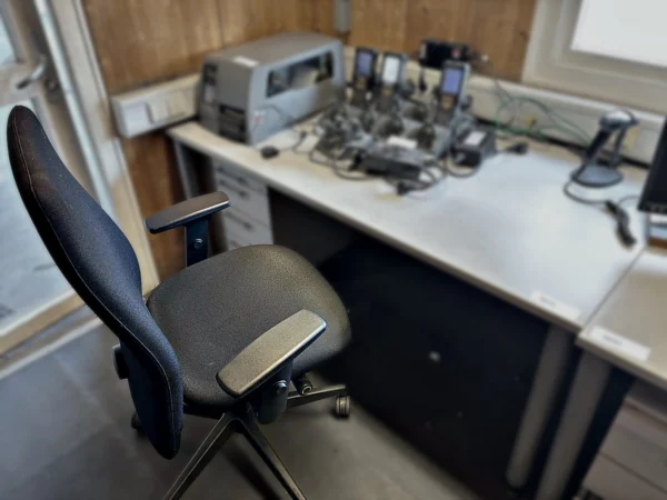 Schreibtisch mit Rollcontainer und Bürodrehstuhl ohne Inhalt