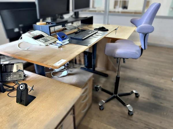 Schreibtisch elektrisch höhenverstellbar mit Standcontainer und Sattel-Bürodrehstuhl